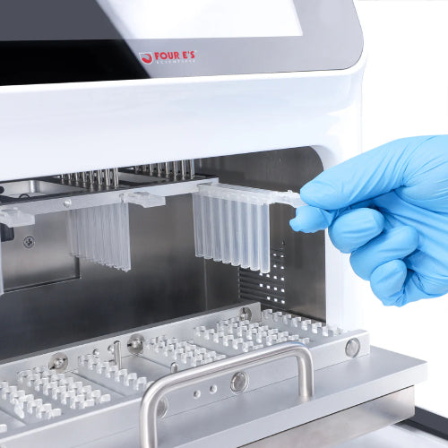 Studio product view of a gloved hand inserting a magnetic rod comb into the upper internal chamber slot of a 4E's USA 32-throughput nucleic acid extraction system against a white background, highlighting its stainless steel interior and slide-out lower platform