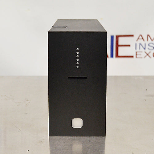 Front eye-level view of a 4E's USA CytoCube portable cell counter on a stainless steel surface, featuring its compact matte black housing, a central sample slot, vertical indicator lights, and a lower power button