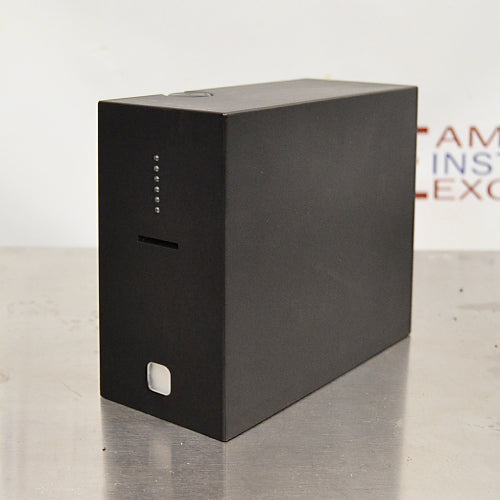Left angled perspective view of a 4E's USA CytoCube portable cell counter on a stainless steel surface, highlighting its compact matte black housing, vertical status indicator lights, sample slot, and lower power button