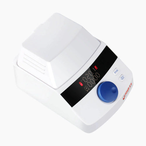 Studio angle product view of a 4E's USA mini block heater with a closed flip-top heated lid against a white background, highlighting its white benchtop housing, digital LED display panel, blue control dial, and function buttons