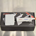 Product view of a 4E's USA Precipette 8-channel adjustable multichannel pipette (0.5-10uL) resting horizontally on top of its branded packaging box on a neutral surface, highlighting its white body and orange plunger cap