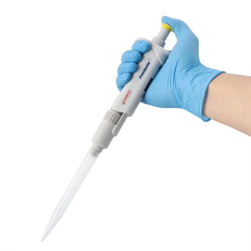 Studio angled product view of a 4E's USA Precipette adjustable pipette (1000-5000uL) being held by a hand in a blue nitrile glove against a white background, highlighting its ergonomic body, yellow plunger cap, and attached tip