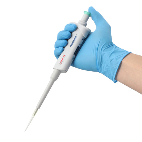 Studio product view of a 4E's USA Precipette adjustable pipette (5-50uL) held at an angle in a gloved hand against a white background, highlighting its ergonomic white body, light green plunger cap, and attached yellow pipette tip