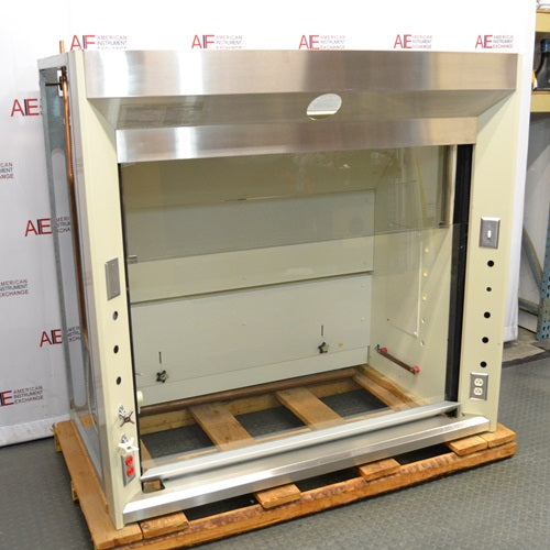 An alternative angled view of a Jamestown chemical fume hood mounted on a wooden pallet in front of an American Instrument Exchange backdrop, showing its stainless steel upper canopy, side profile, and interior workspace.