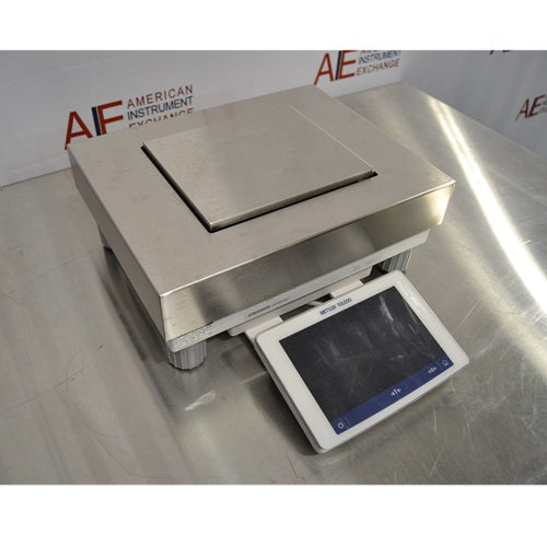 An alternative angled view of a Mettler Toledo XPR20002L Delta Range precision balance available from American Instrument Exchange, showing its square weighing pan and front-mounted digital touchscreen display.