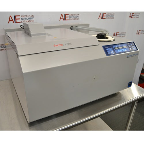 An alternative angled view of a Thermo Savant SpeedVac SPD2030 vacuum concentrator system on a stainless steel lab table, highlighting the front housing, control panel, and top cover assembly.