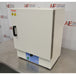 An alternative angled view of a Thermo Scientific PR305225G Precision laboratory oven sitting on a stainless steel surface in front of an American Instrument Exchange backdrop, highlighting its right side panel, door hinges, front handle, and blue control panel.