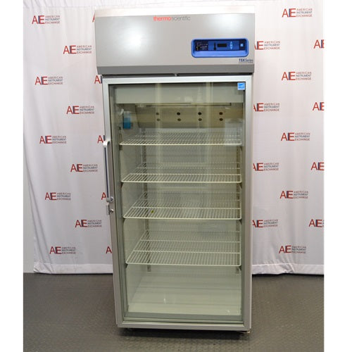 An alternative angled view of a Thermo Scientific TSX3005GA high-performance lab refrigerator available from American Instrument Exchange, showing its glass door and internal wire shelving.