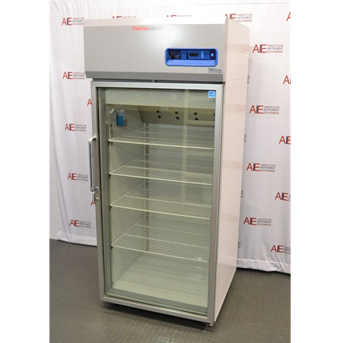 An alternative front-facing view of a Thermo Scientific TSX3005GA high-performance lab refrigerator available from American Instrument Exchange, showing its glass door, internal wire shelving, and top-mounted digital control panel.