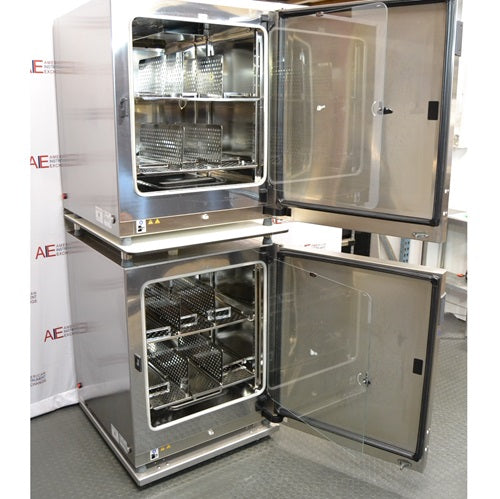 An alternative interior view of two stacked, open-door Thermo Scientific Heracell VIOS 250i CR CO2 incubators available from American Instrument Exchange, highlighting the internal shelving.