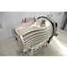 An angled view of the metallic Edwards nXDS 10i dry scroll vacuum pump, highlighting its ribbed exterior design, ports, and base control panel against an American Instrument Exchange backdrop.