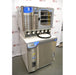 An angled view of the Labconco FreeZone 6-liter freeze dryer system and its attached stoppering tray dryer, showcasing the stainless steel construction, drying ports, and control interface, all positioned in front of an American Instrument Exchange backdrop.