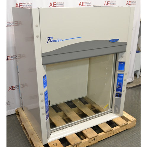 An angled view of a Labconco Protector Premier chemical fume hood mounted on a wooden pallet in front of an American Instrument Exchange backdrop, highlighting the left side panel, Premier branding, clear glass sash, and side utility controls.