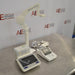 An angled view of a Mettler Toledo SevenExcellence multiparameter meter setup on a stainless steel surface in front of an American Instrument Exchange backdrop, displaying the touchscreen terminal in the foreground, connected expansion modules, attached electrode arm, compact printer, and power supply cables.
