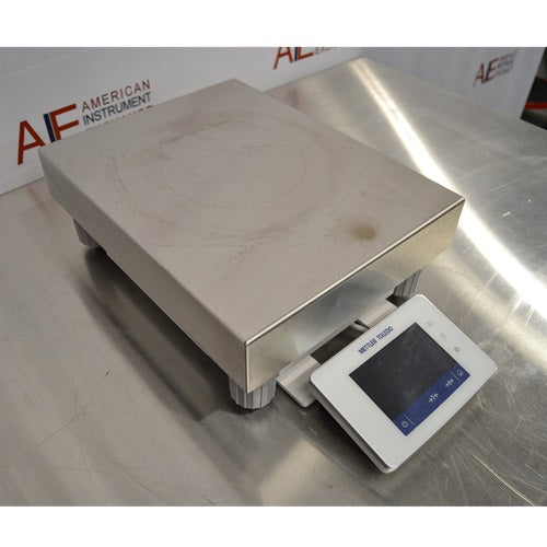 An alternative angled view of a Mettler Toledo XSR32001DR laboratory balance available from American Instrument Exchange, showing its large weighing pan and front-mounted digital touchscreen display.