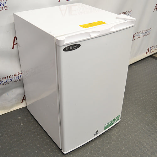 Angled view of Norlake Scientific undercounter laboratory refrigerator showing top warning sticker and front door logo