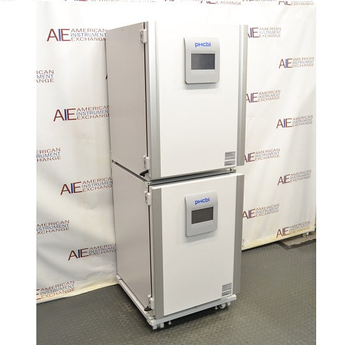 An angled view of two stacked PHCbi Cell-IQ series tri-gas cell culture incubators available from American Instrument Exchange, showing their control panels and white exterior.