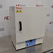 An angled view of a Thermo Scientific PR305225G Precision laboratory oven sitting on a stainless steel surface in front of an American Instrument Exchange backdrop, displaying its front door, vertical handle, left side panel, and blue control panel.