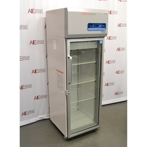 An angled view of a Thermo Scientific TSX1205GA laboratory refrigerator available from American Instrument Exchange, showing its glass door and internal wire shelving.