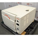 An angled view of a Tuttnauer 3870ELP-B/L-D benchtop autoclave resting on a pallet in front of an American Instrument Exchange backdrop, displaying its front door, right side panel with ventilation louvers, control interface, pressure gauge, and top housing.