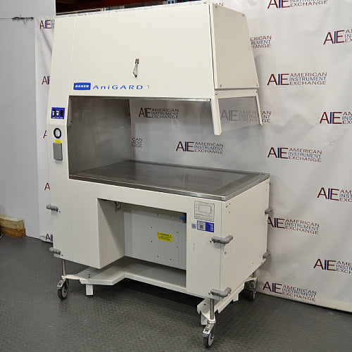 A Baker AniGARD e3 Animal Transfer Station, white in color, with a clear glass window and electronic controls on the top. It is set against a backdrop featuring the AIE Laboratory Services branding.