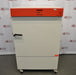 A white, upright Binder KB240 refrigerated incubator with a distinctive orange control panel, positioned in front of an American Instrument Exchange backdrop.
