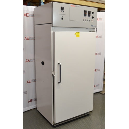 An angled view of a Thermo Forma 3940 refrigerated environmental chamber with its door closed in front of an American Instrument Exchange backdrop, showing its front door handle, side panel, and top grey control console.