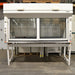 A white Fisher Hamilton 8' Chemical Fume Hood with a base stand, featuring a glass sash, a white epoxy work surface, and various fixtures such as monkey bars and external duplex outlets.