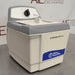 Three-quarter side-angled studio view of a Fisher Scientific M1800 1.9L ultrasonic bath on a stainless steel surface, featuring its white and grey housing, front branding panel, and rear mechanical timer dial