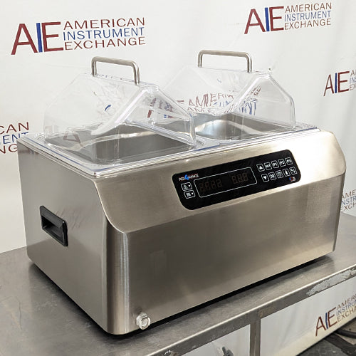 Front-angled view of Four E's USA 24L Per4mance stainless steel water bath featuring dual transparent gable covers, a digital control panel, side carrying handles, and an American Instrument Exchange backdrop