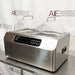 Front-right angled view of Four E's USA 24L Per4mance stainless steel water bath featuring dual transparent gable covers, digital control panel, and side carrying handle against an American Instrument Exchange backdrop