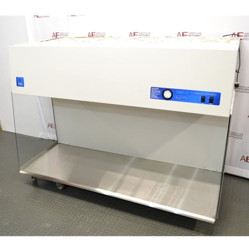A front-angled view of the Labconco Purifier Horizontal Clean Bench model 3873021, displaying its white overhead unit with integrated control panel, expansive stainless steel work surface, and transparent side panels, set against an American Instrument Exchange backdrop.