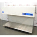 A front-angled view of the Labconco Purifier Horizontal Clean Bench model 3873021, displaying its white overhead unit with integrated control panel, expansive stainless steel work surface, and transparent side panels, set against an American Instrument Exchange backdrop.