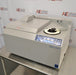 A front-facing angled view of a Thermo Savant SpeedVac SPD2030 vacuum concentrator system on a stainless steel lab table, showing its integrated control panel, vacuum tubing, and top cover housing.