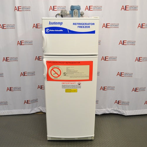 A front-facing view of a Fisher Scientific Isotemp explosion-proof laboratory refrigerator/freezer combination unit, showing its white double-door exterior, top-mounted compressor housing, and prominent red safety warning labels.