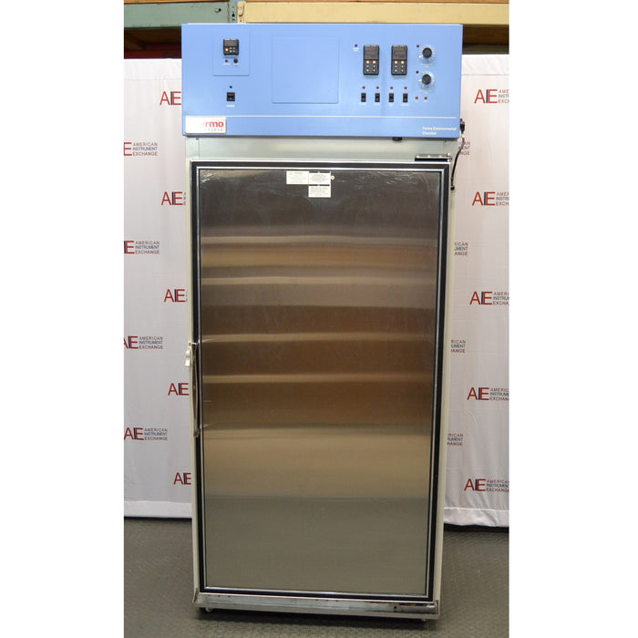A front-facing view of a Thermo Forma 3920 environmental chamber, showing its solid stainless steel door and the top-mounted blue control console housing digital displays and switches.