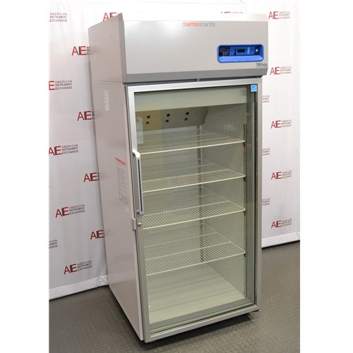 A front-facing view of a Thermo Scientific TSX3005GA high-performance lab refrigerator available from American Instrument Exchange, showing its glass door, internal wire shelving, and top-mounted digital control panel.