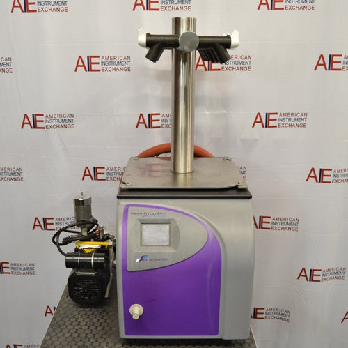 Head-on front view of an SP Scientific BenchTop Pro freeze dryer resting on a benchtop, featuring a purple front casing, display screen, top multi-port tree manifold, and attached vacuum pump to the left.