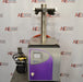 Head-on front view of an SP Scientific BenchTop Pro freeze dryer resting on a benchtop, featuring a purple front casing, display screen, top multi-port tree manifold, and attached vacuum pump to the left.