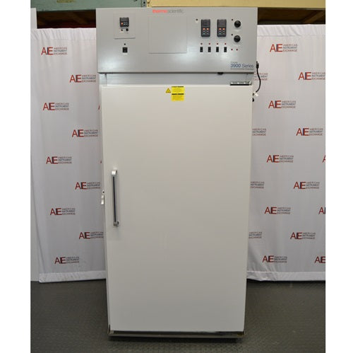 A front-facing view of a Thermo Forma 3940 refrigerated environmental chamber in front of an American Instrument Exchange backdrop, showing its solid white exterior door, side handle, and top grey control console with digital displays and switches.
