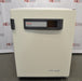 A front-facing view of a Thermo Heracell VIOS 250i LK CO2 incubator in front of an American Instrument Exchange backdrop, featuring a solid white outer door, a dark gray top control strip with touchscreen display, door latch, and Heracell VIOS 250i branding on the lower right.