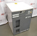 An elevated front-left view of a grey and white Atlas Copco SF 4 FF oil-free scroll air compressor, showing the control panel, pressure gauge, side paneling, and front ventilation vents against an American Instrument Exchange backdrop.