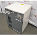 An elevated front-right view of a grey and white Atlas Copco SF 4 FF oil-free scroll air compressor, showing the control panel, pressure display, side casing, and front ventilation vents against an American Instrument Exchange backdrop.
