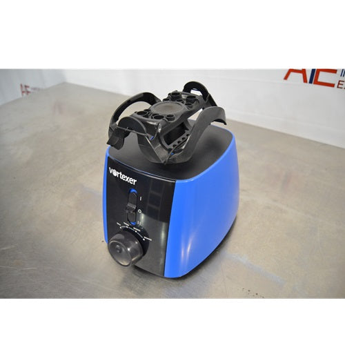 An elevated front-right view of a blue and black Heathrow Scientific Vortexer on a metal surface, showcasing the multi-tube holder attachment, front power switch, and speed adjustment knob.