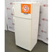 An elevated side-angle view of a white Thermo Scientific 10FCEETSA flammable material combination refrigerator/freezer on a lab floor, showing the top freezer door with a safety warning sign and the lower refrigerator door against an American Instrument Exchange backdrop.