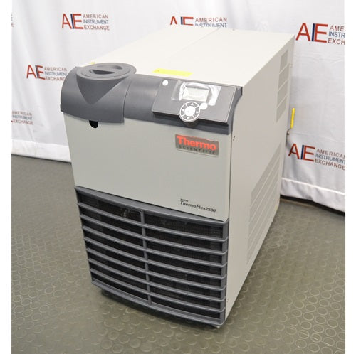 A high-angle view of the Thermo Scientific ThermoFlex 2500 recirculating chiller, showcasing its top control interface, beige cabinet, and front intake grille in front of an American Instrument Exchange backdrop.