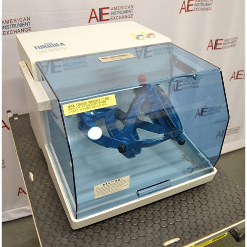A high-angle view of the Willy A. Bachofen TURBULA T2 three-dimensional shaker mixer with its blue transparent safety enclosure, displayed against an American Instrument Exchange backdrop.