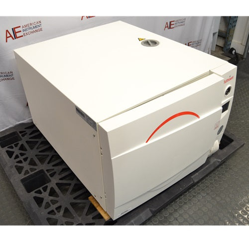 A high-angled perspective view of a Tuttnauer 3870ELP-B/L-D benchtop autoclave resting on a pallet in front of an American Instrument Exchange backdrop, displaying its front door, left side panel with serial label, top cover, and right side control panel.