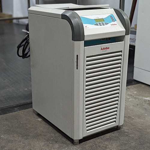 A Julabo FL601 recirculating chiller, with a gray body and blue details, standing on a warehouse floor.
