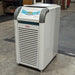 A Julabo FL601 recirculating chiller, with a gray body and blue details, standing on a warehouse floor.